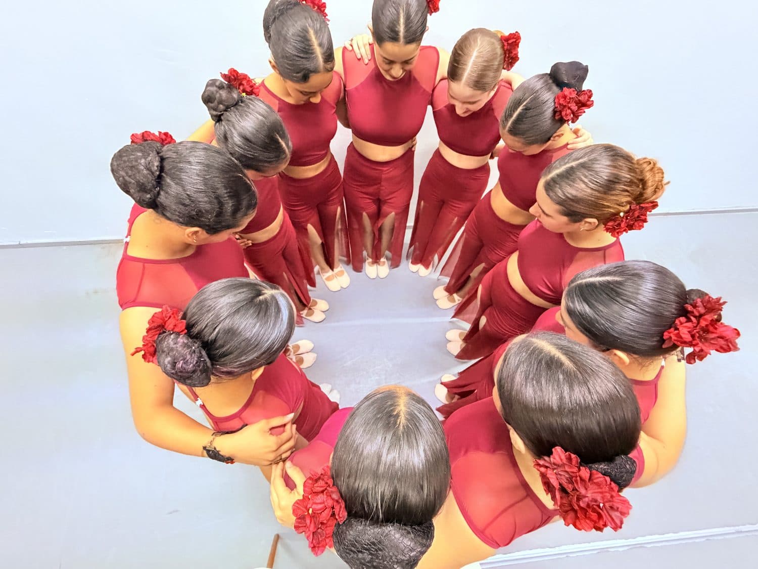 Estudiantes de la Cátedra de Danza en leotardo rojo formando un círculo, vista desde arriba